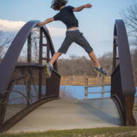 brown haired boy jumping off bridge